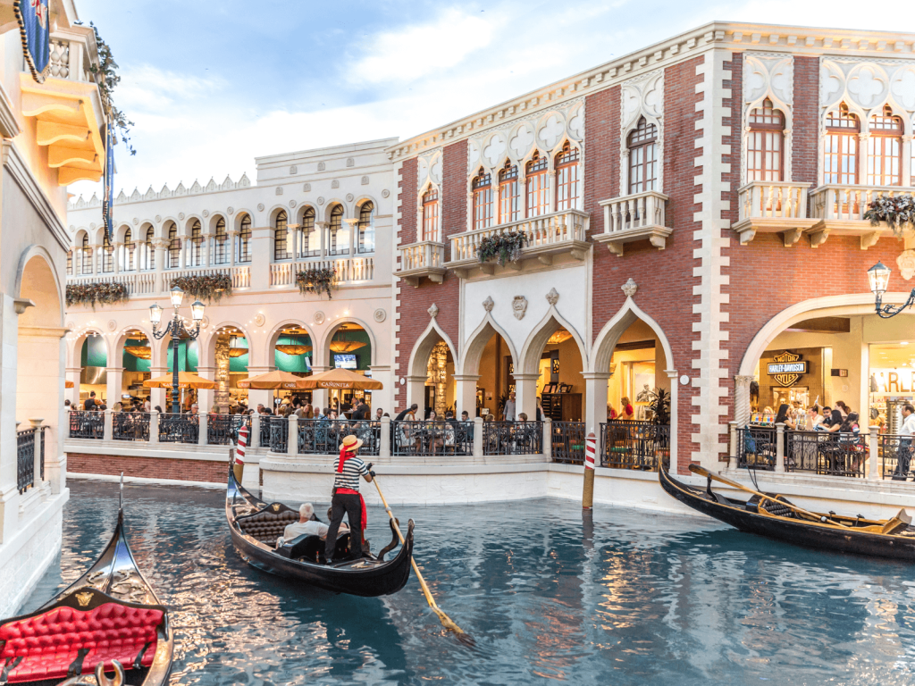 Gondolas traveling along the indoor canal at The Venetian in Las Vegas, surrounded by Venetian inspired architecture, perfect for Las Vegas captions.