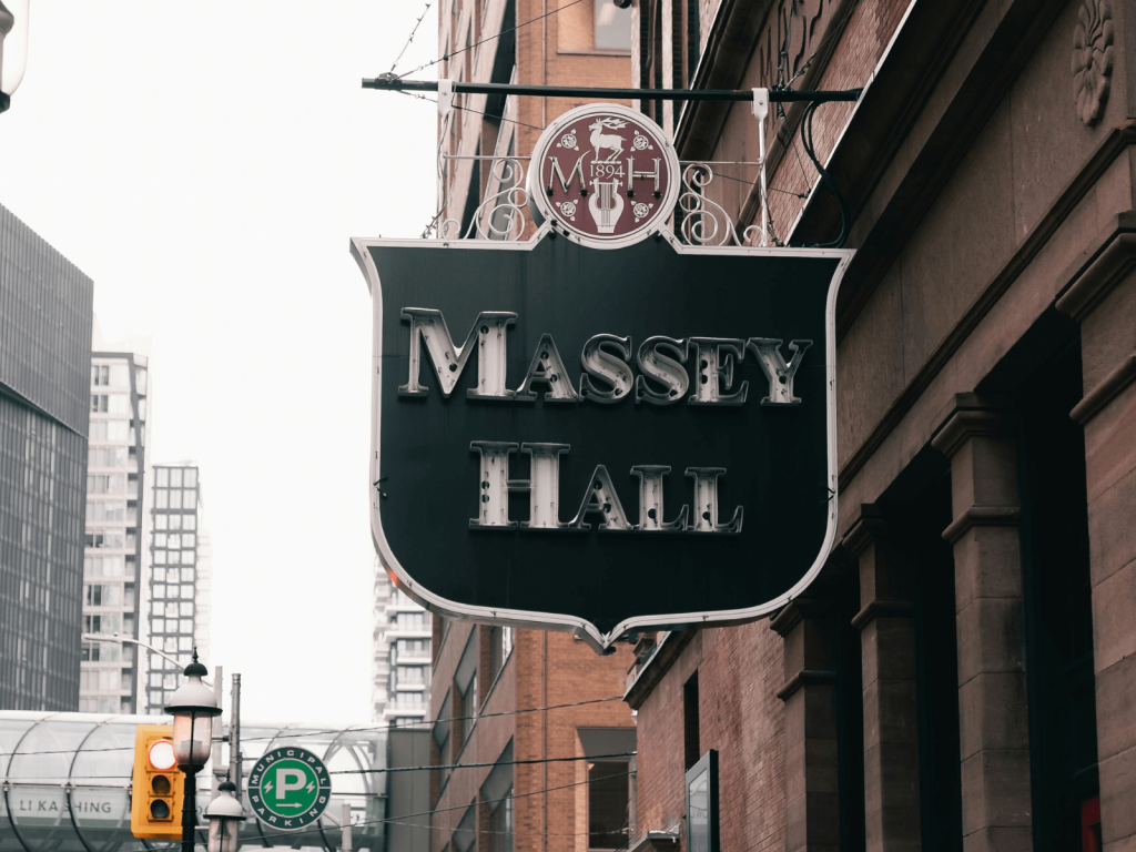Massey Hall sign hanging outside the historic Toronto music venue along a downtown street.