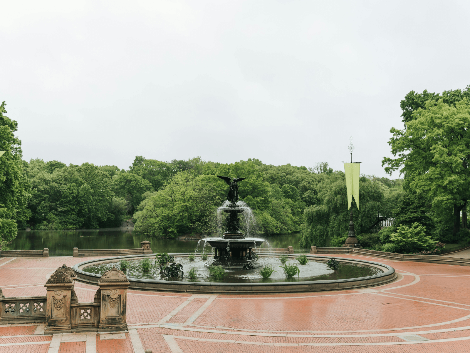 Bethesda Fountain surrounded by lush green trees and brick walkways in Central Park, New York City, perfect for Central Park captions.