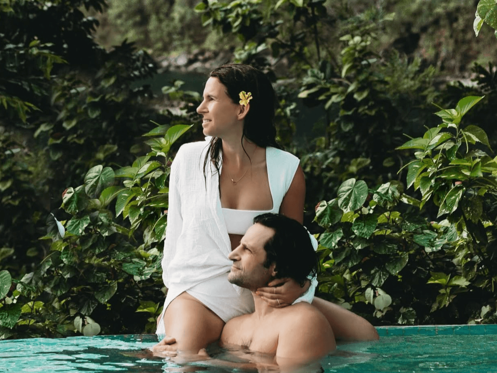 Couple relaxing together in a tropical infinity pool surrounded by lush greenery during a St. Lucia itinerary.