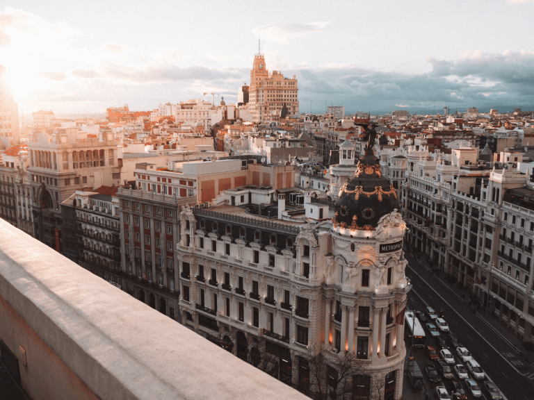 Sunset view over Madrid’s Gran Vía featuring the ornate Metropolis Building and surrounding city architecture, perfect for Spain captions.