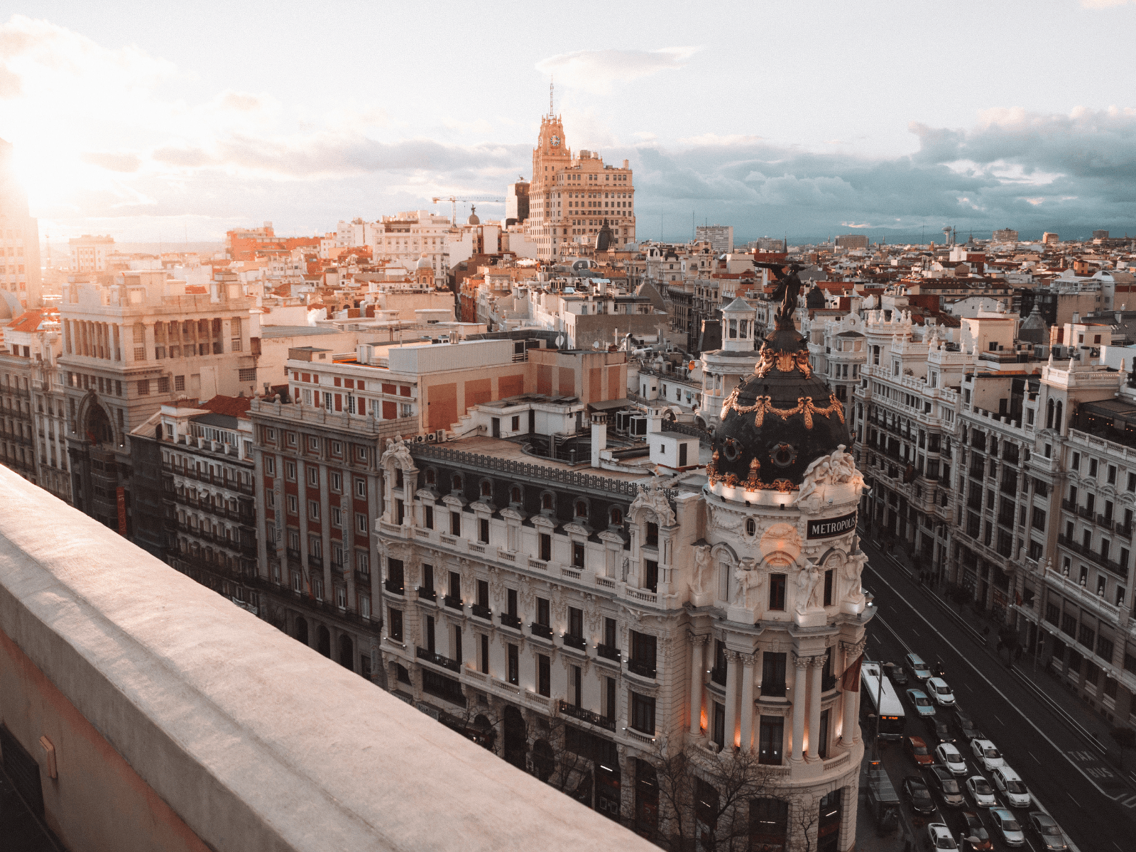 Sunset view over Madrid’s Gran Vía featuring the ornate Metropolis Building and surrounding city architecture, perfect for Spain captions.