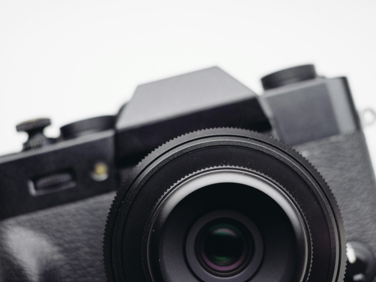 Close up of a black camera and large lens representing essential camera gear for photography.