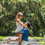 A couple enjoying a romantic moment under the canopy of moss-covered oak trees on a sunlit path — a dreamy stop during 2 days in Savannah, Georgia.