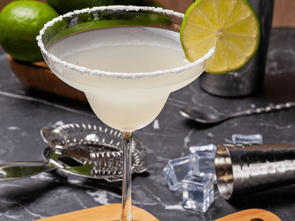 Classic margarita in a stemmed glass with a salted rim and fresh lime, one of many cocktails around the world enjoyed by travelers.