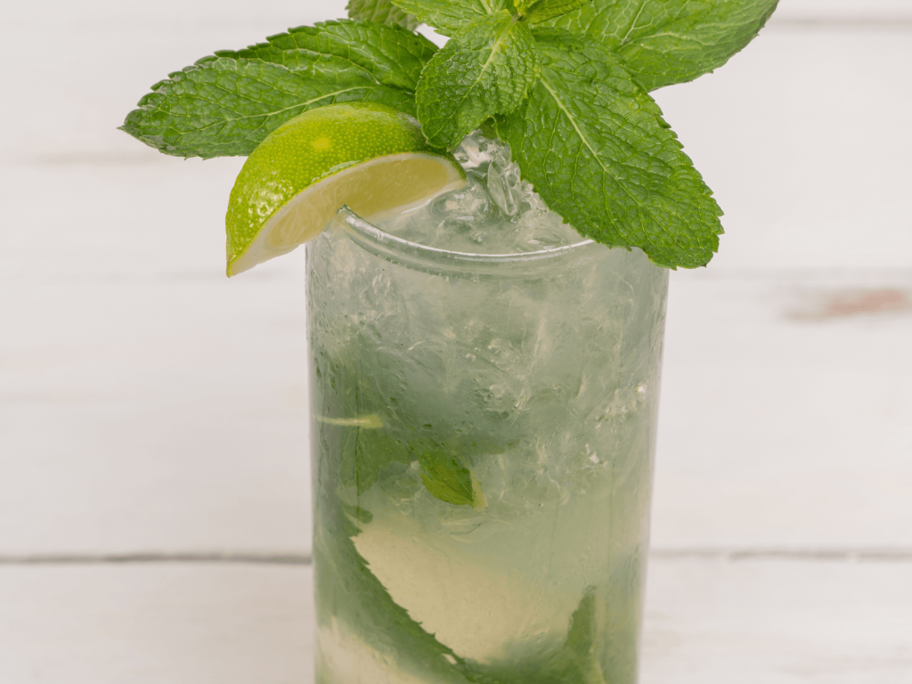 Mojito served over crushed ice with fresh mint leaves and a lime wedge.