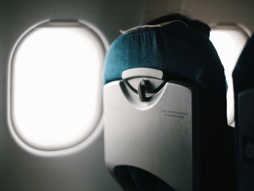 Airplane seat and window inside a plane, showing the cabin setup parents may use when flying with a baby.